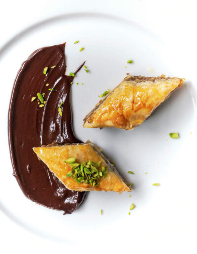 Baklava with chocolate on white plate and pistaccios